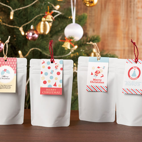 マットニス加工が落ち着いた雰囲気の白いチャック付蒸着スタンド袋を、お手軽プリントで作製した2つ折りカードで挟み、パンチで穴をあけて麻コードを結んだクリスマス向けのパッケージです。